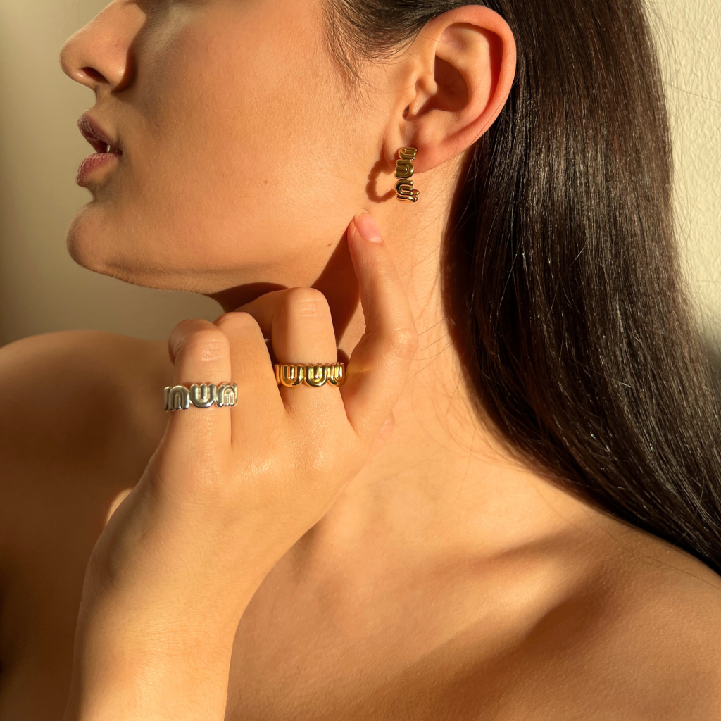 SUUS jewelry model wearing sterling silver half-hoop earrings and rings